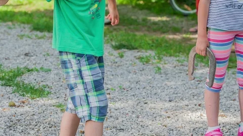 Boy is preparing to throw an iron horseshoe Stock Footage 100058369