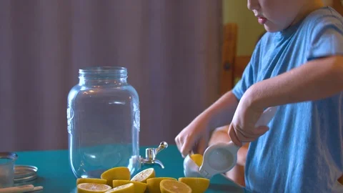 Boy Pressing Lemons into a Jar to Make Lemonade Stock Footage 94395306