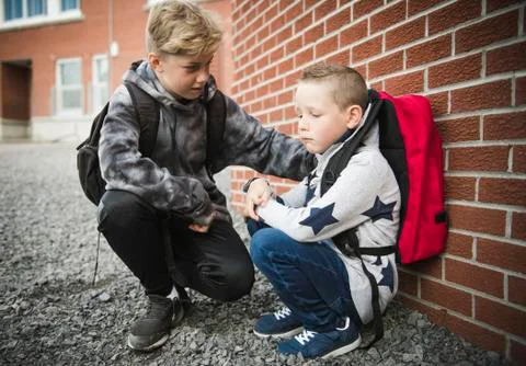 Boy problem at school, sitting and consoling child each other Stock-Fotos