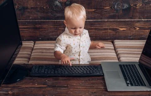 Boy programming on computer with multiple monitors and laptop on desk 库存照片