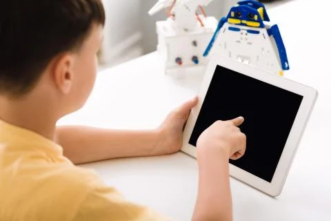 Boy programming electric toy with tablet computer Foto stock
