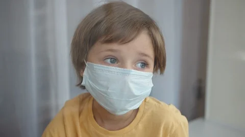 A boy in a protective mask by the window 動画素材 128864736