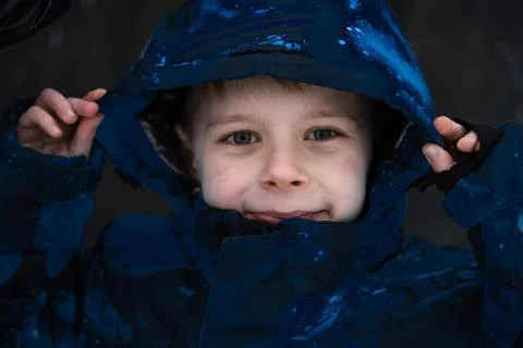 The boy pulled the hoodie in his jacket over his head. Stock Photos