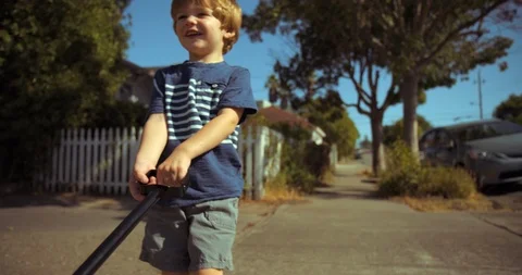 Boy pulling a cart along the sidewalk 스톡 동영상 88372442