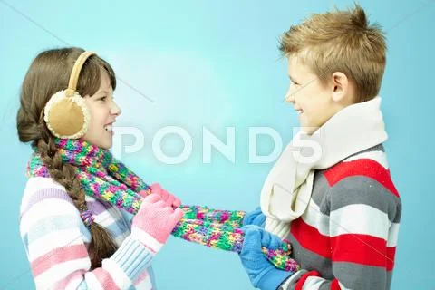 Boy pulling colorful scarf on a little girl Stock Photos
