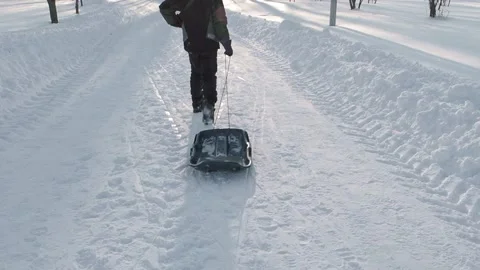 Boy pulling a sled Stock Footage 237478937
