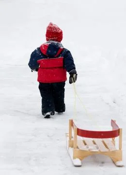 Boy pulling sled Stock Photos