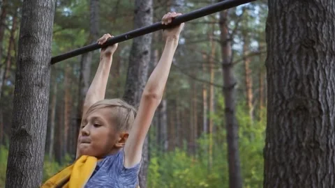 The boy pulls himself up on the bar and jumps down Stock Footage 147249967