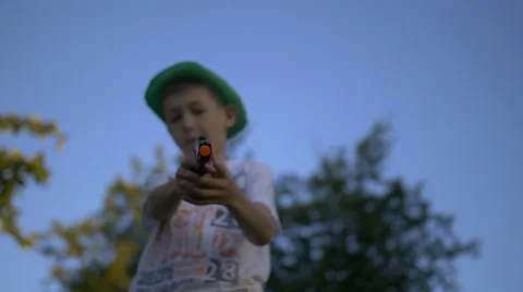 Boy pulls out a gun and shoots at the camera, gangster, slow motion Video stock 67988861