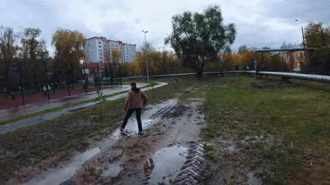 A boy pulls a soccer ball out of a puddle, a child with a soccer ball Stock Footage 217968749