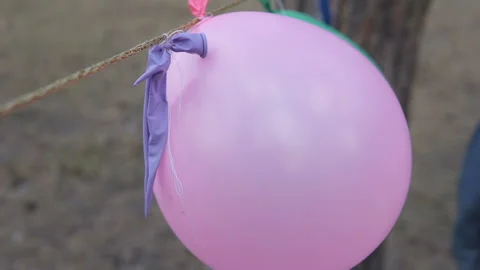 A boy punctures an inflatable balloon and it bursts Stock Footage 120288253