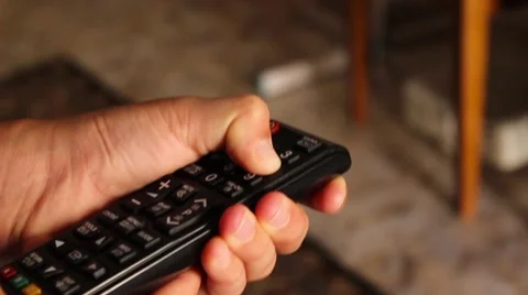 The boy pushes buttons on the remote control to the TV Stock Footage 65302154