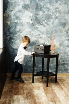 A boy pushing a table with a box for Christmas decorations and tree Stock-Fotos