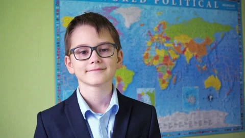 The boy puts on and adjusts his glasses while standing against the background of Stock Footage 169466719