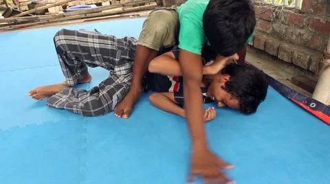 Boy puts an arm hold on another, who struggles,practicing jiu jitsu wrestling Stock Footage 58469190