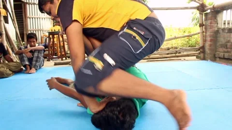 Boy puts an arm hold on another while practicing jiu jitsu wrestling Stock Footage 58469768