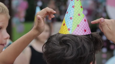 Boy puts on a birthday hat Stock Footage 138903175