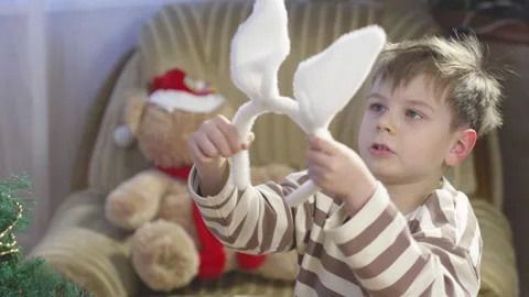 A boy puts bunny ears on his head Vídeos de archivo 266386183
