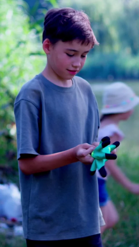 A boy puts on gloves to start cleaning up on the riverbank. Stock Footage 340577890