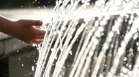 Boy puts his hands under running water of the fountain, slow motion 4 Stock Footage 51375021