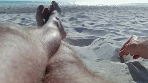 A boy putting out his cigarette in the sand and leaving it there Stock Footage 250186822