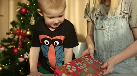 Boy Putting Packed Gift under the Christmas Tree Stock Footage 60362302