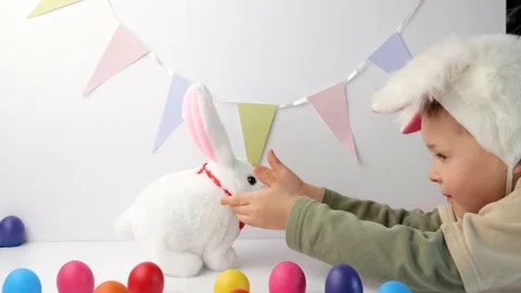 Boy in rabbit ears on head play with cute toy bunny Stock-Footage 148863827