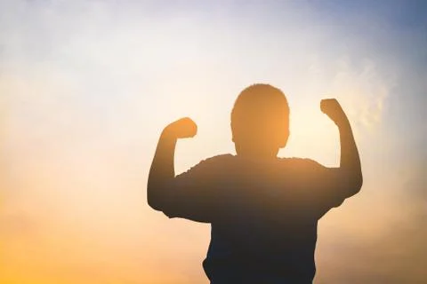 The boy raised both hands, feeling energetic in the morning. silhouette Stock Photos