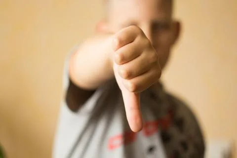 The boy raised a thumb down Stock Photos