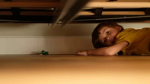Boy reaching toy under bed Stock Footage 127822634