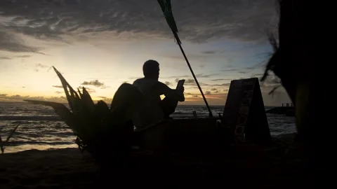 A boy is reading a book during sunset on the beach in Srí lanka Stock Footage 167120075