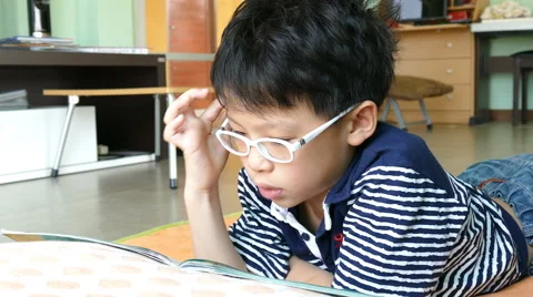 Boy reading book on the floor Stock Footage 61942726