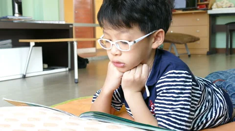 Boy reading book on the floor Stock Footage 61943508