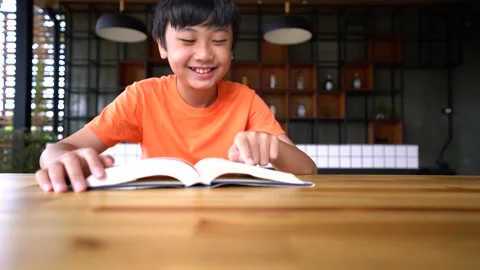 A boy reading a book at home for relax Stock Footage 144324879