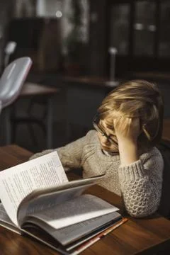 The boy is reading a book in the library 写真素材