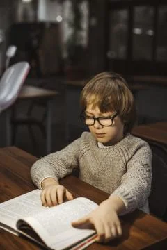 The boy is reading a book in the library 写真素材