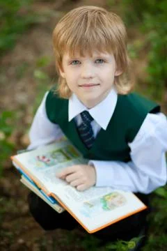 Boy reading book in the park Stock Photos