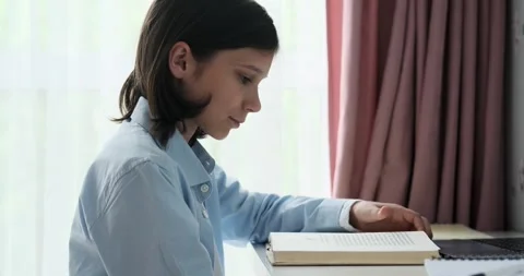 Boy Reading a Book at the Table Stock Footage 250029064