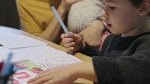 Boy reading the condition of the exercise and starting to write with a pen Stock Footage 170035545