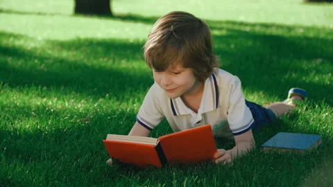 Boy reading paper book Stock Footage 136639276