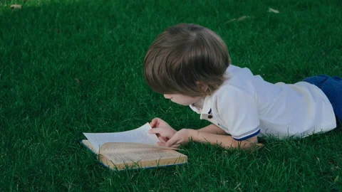 Boy reading paper book Video stock 136642087