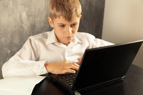 The boy receives education remotely using a computer. Back to school Stock Photos