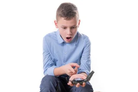 Boy recognizes on a compass in his hand the right direction for the future on Stock Photos