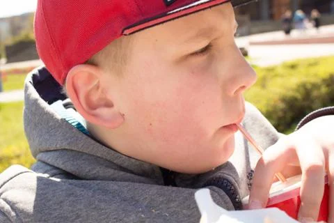The boy in the red cap is drinking lemonade Stock Photos