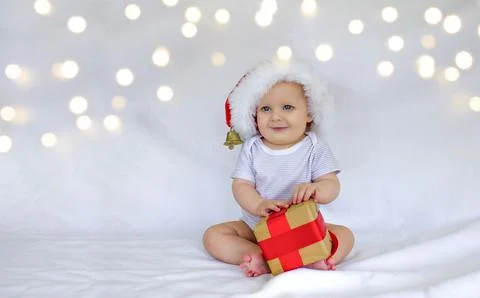 A boy in a red hat with a gift is sitting and smiling Stock Photos