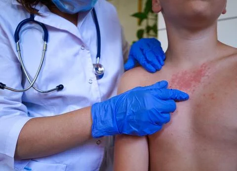 A boy with a red rash is being checked by the physician. Stock Photos