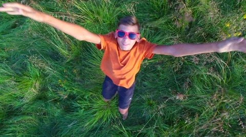 Boy in a red sunglasses having fun in a mountain meadow Stock Footage 66131593