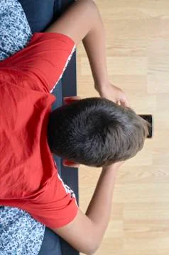 Boy with red t-shirt using his mobile Foto stock