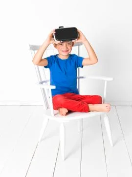 Boy with red trousers and blue shirt is using virtual glasses at home Stock Photos
