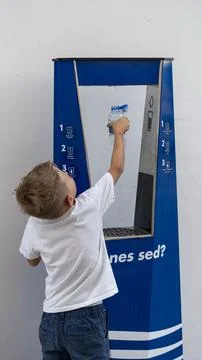 Boy Refilling Plastic Water Bottle at Public Drinking Fountain 스톡 사진